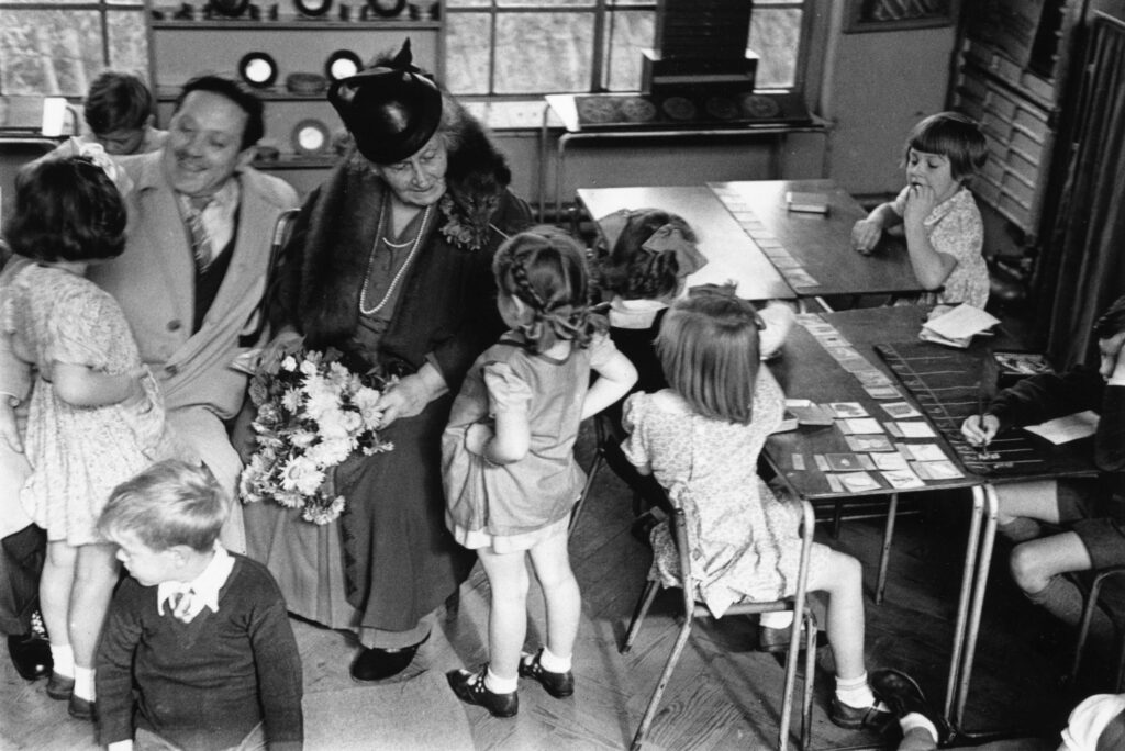 Italian educator Maria Montessori teaching children in a classroom